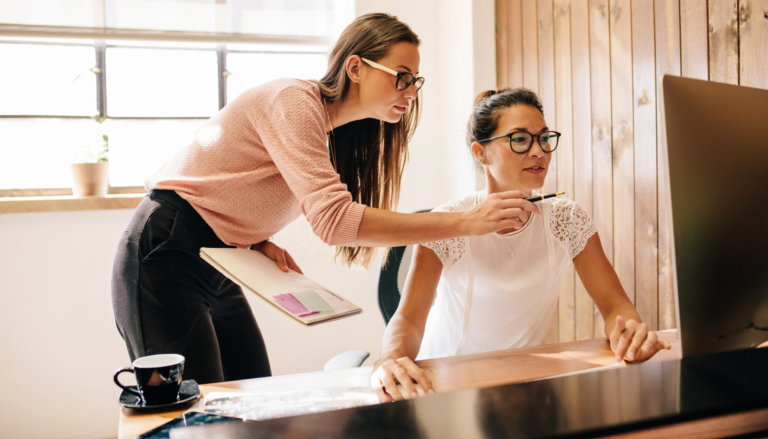 two women using computer in office